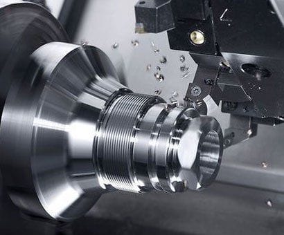 CNC turning operation producing a threaded steel component